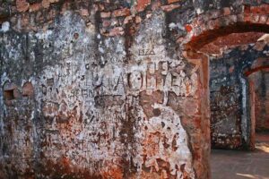 Mur de pierre rouge avec peinture blanche écaillée et dégradée par l'usure