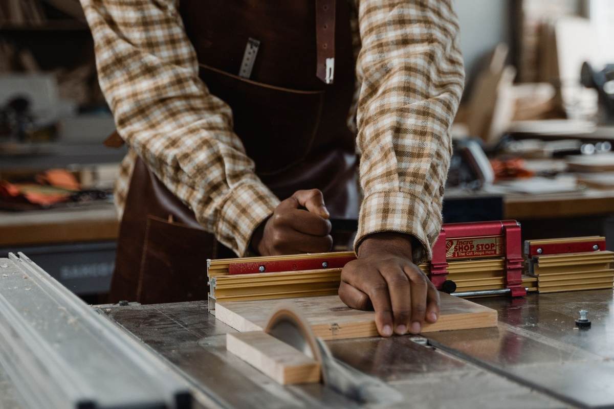 Homme utilisant une scie pour couper du bois dans un atelier Homme utilisant une scie pour couper du bois dans un atelier