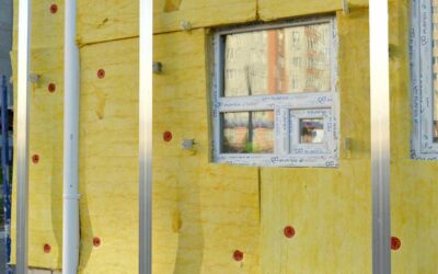 Vue d'une façade isolante avec fenêtre et poteaux métalliques