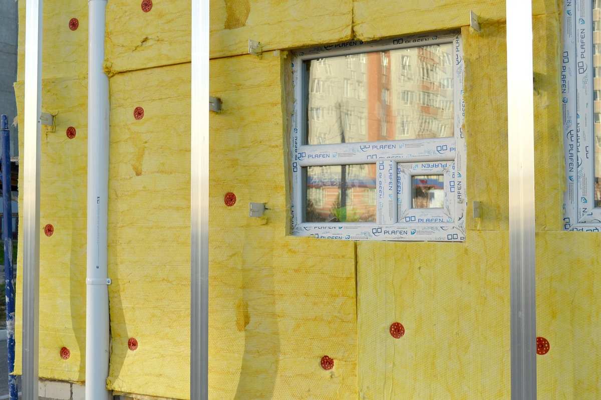 Vue d'une façade isolante avec fenêtre et poteaux métalliques