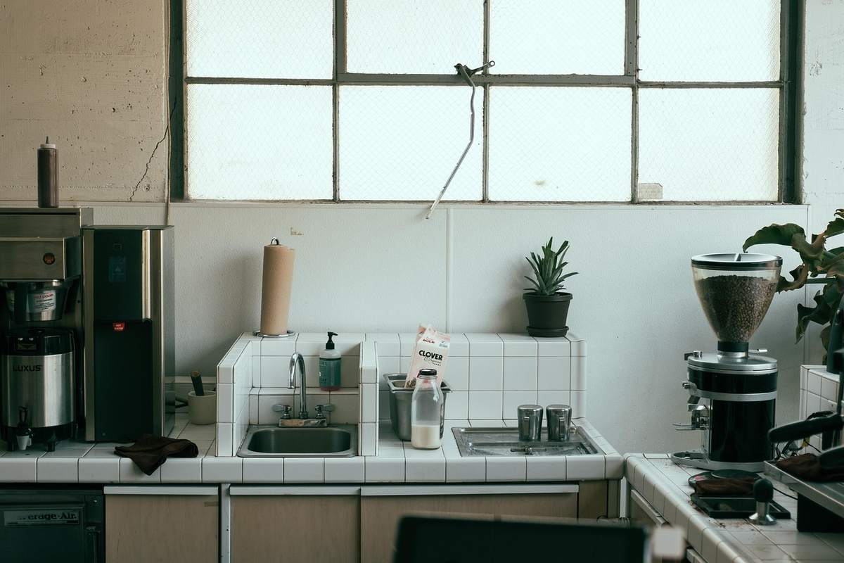 Cuisine avec évier, cafetière, grille-pain, plantes, fenêtre Cuisine avec évier, cafetière, grille-pain, plantes, fenêtre