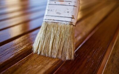 Pinceau appliquant une finition protectrice sur des lames de parquet en chêne verni