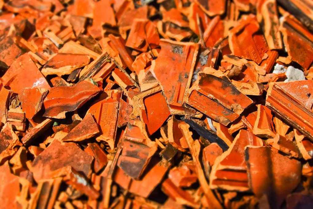 Pile de fragments de tuiles en terre cuite brisées couleur orangée